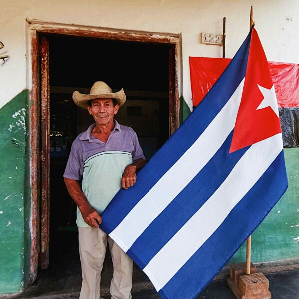 Un monsieur nous racontant son histoire tenant le drapeau cubain