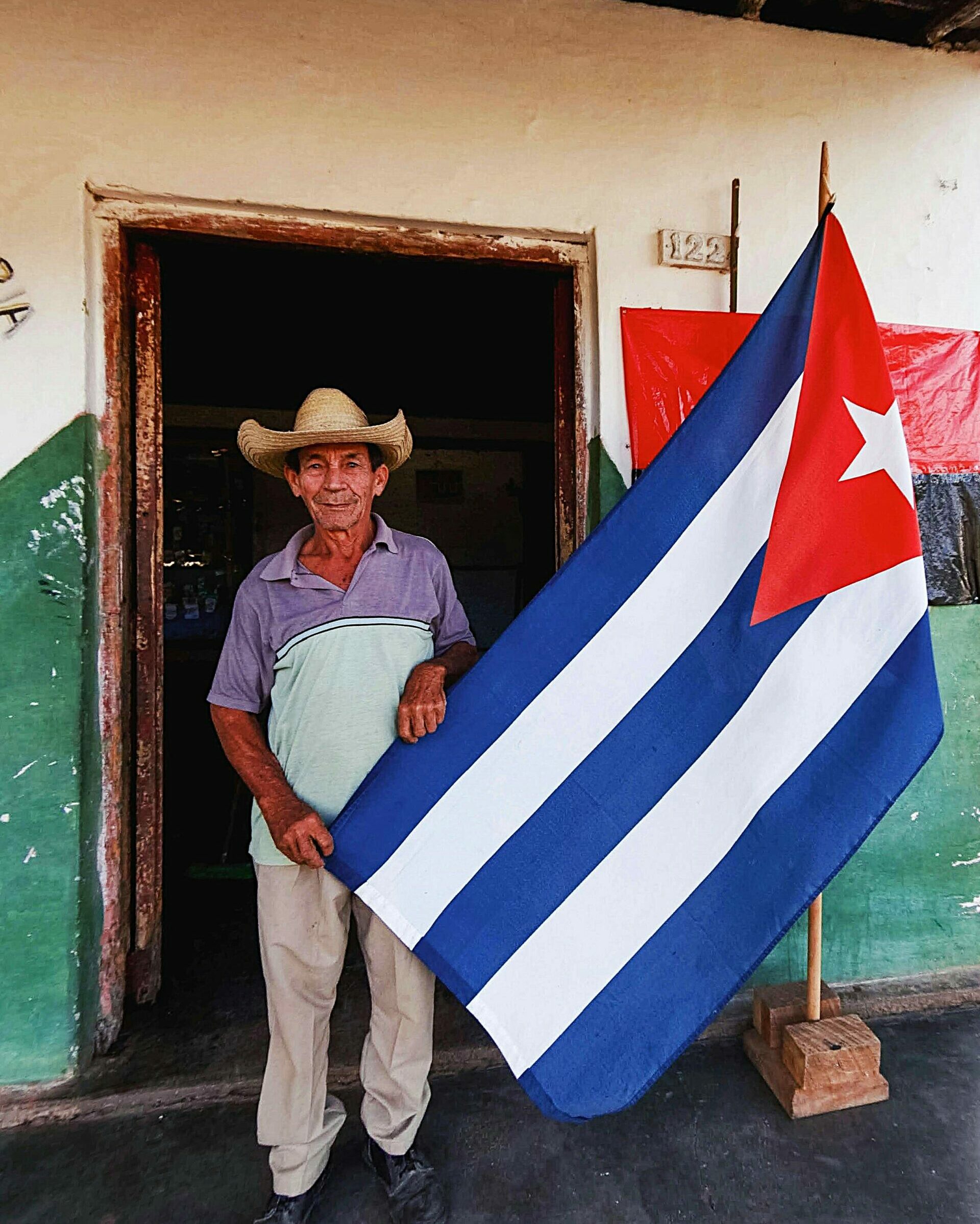 Un monsieur nous racontant son histoire tenant le drapeau cubain